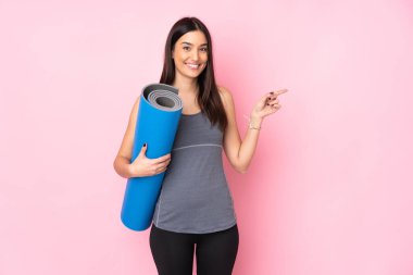 Pembe arka planda paspası olan beyaz bir kadın parmak işareti yapıyor.