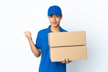 Çinli adam beyaz arka planda izole edilmiş bir şekilde bir ürün sunmak için kenarı işaret ediyor.