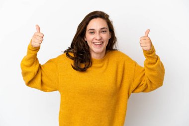 Beyaz arka planda izole edilmiş genç beyaz bir kadın baş parmak hareketi yapıyor.