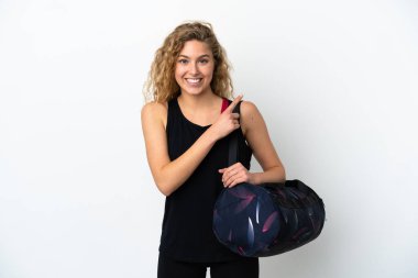 Spor çantalı genç bayan beyaz arka planda izole edilmiş bir ürün sunmak için kenarı işaret ediyor.