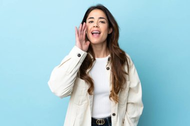 Woman over isolated background shouting with mouth wide open