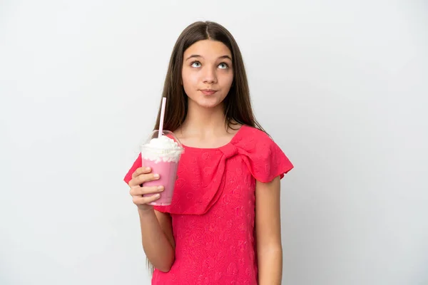 Liten Flicka Med Jordgubbsmjölkshake Över Isolerad Vit Bakgrund Och Tittar — Stockfoto