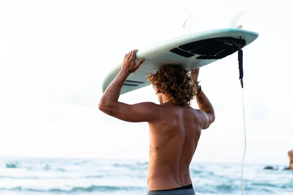 Young caucasian man get up early to  doing surf at sunrise