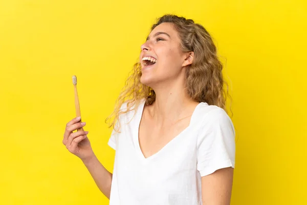 Молода Біла Жінка Тримає Чистячі Зуби Ізольовані Жовтому Тлі Сміючись — стокове фото