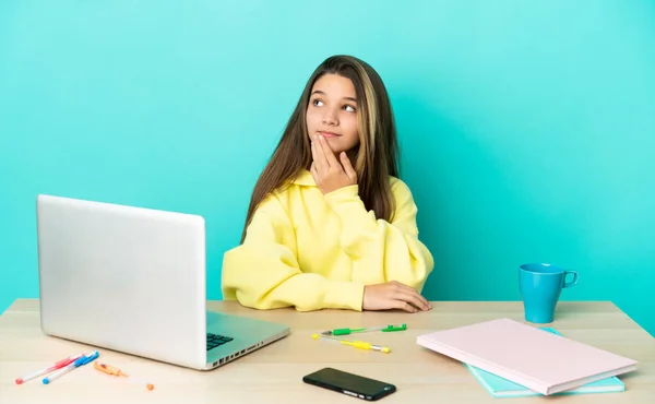 Menina Uma Mesa Com Laptop Sobre Fundo Azul Isolado Olhando — Fotografia de Stock