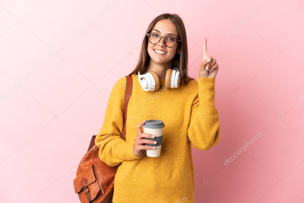 Young student woman over isolated pink background pointing up a great idea