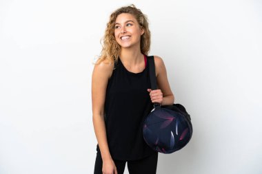 Spor çantalı genç bir kadın beyaz arka planda izole edilmiş bir şekilde yukarı bakarken bir fikir düşünüyor.