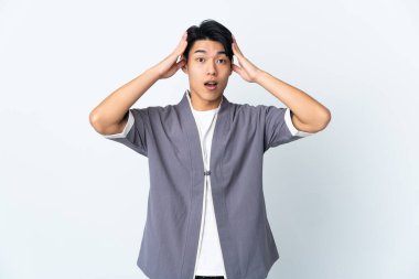 Beyaz arka planda, sürpriz bir ifadeyle izole edilmiş genç bir Çinli.