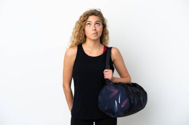 Spor çantalı genç bayan beyaz arka planda izole edilmiş ve yukarı bakıyor