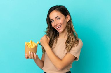 Kızarmış cipsleri izole edilmiş arka planda tutan genç bir kadın zaferi kutluyor.