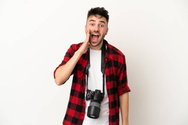 Beyaz arka planda, şaşırmış ve şok olmuş yüzü olan genç bir fotoğrafçı.