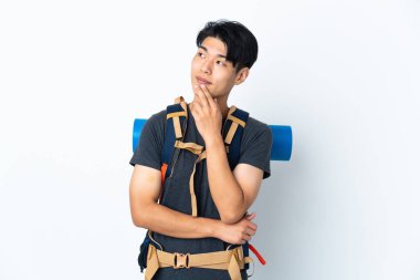 Dağcı Çinli adam beyaz arka planda izole edilmiş gülümserken yukarı bakıyor.