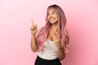 Pembe saçlı genç melez kadın pembe arka planda izole edilmiş işaret parmağı ile işaret etmek harika bir fikir.