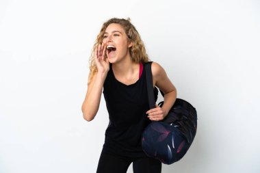Spor çantalı genç kadın beyaz arka planda izole edilmiş ağzı açık bağırıyor.