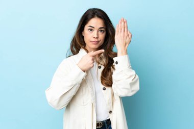 Woman over isolated background making the gesture of being late