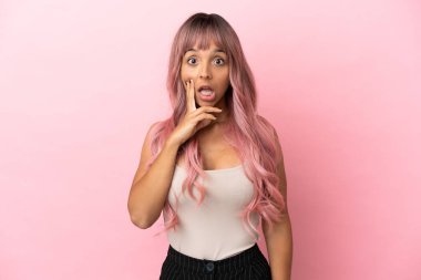 Pembe saçlı melez bir kadın. Pembe arka planda, şaşırmış ve şok olmuş bir yüz ifadesi var.