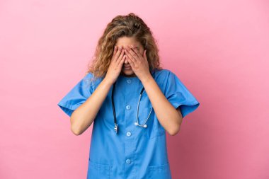 Genç cerrah kadın. Pembe arka planda izole edilmiş. Yorgun ve hasta bir ifadeyle.