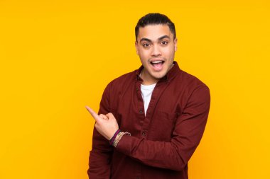 Asyalı yakışıklı adam sarı arka planda izole edilmiş, yorgun ve hasta bir ifadeyle.