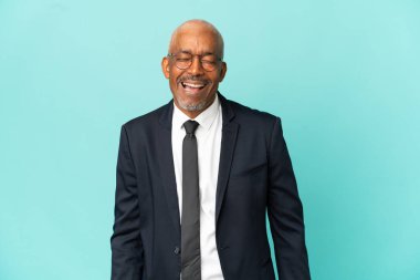 İşletme son sınıf öğrencisi mavi arka planda tek başına gülerek duruyor.