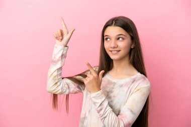 İzole edilmiş pembe arka planda küçük bir kız işaret parmağıyla işaret etmek harika bir fikir.