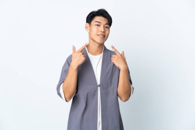 Beyaz arka planda izole edilmiş genç bir Çinli baş parmak hareketi yapıyor.