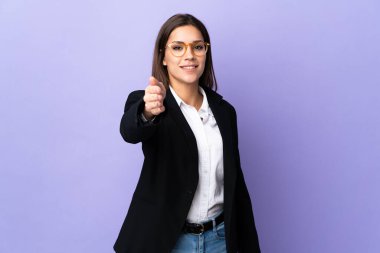 Mor arka planda izole edilmiş bir iş kadını iyi bir anlaşma için el sıkışıyor.
