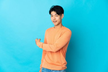 Mavi arka planda izole edilmiş genç bir Çinli.