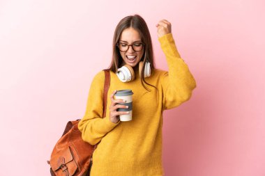 Tecrit edilmiş genç bayan öğrenci pembe arka plan zaferi kutluyor.