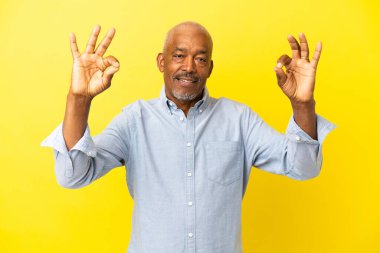 Küba Senior 'u Zen pozunda sarı arka planda izole edildi