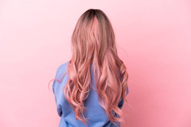 Pembe saçlı melez bir kadın. Pembe arka planda izole edilmiş.