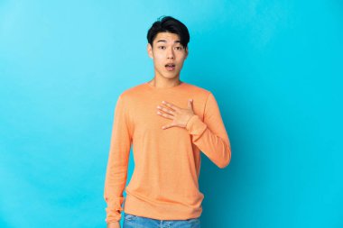 Mavi arka planda mahsur kalmış genç bir Çinli sağa bakarken şaşırmış ve şok olmuştu.