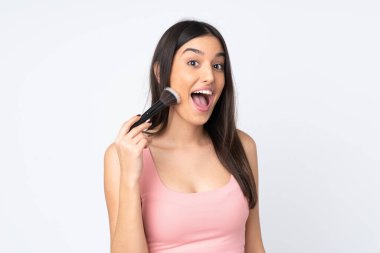 Beyaz arka planda izole edilmiş, elinde makyaj fırçası olan beyaz bir kadın.