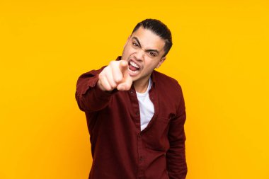 Asyalı yakışıklı adam sarı arka planda izole edilmiş bir ilan vermek için kopyalama alanı tutuyor.