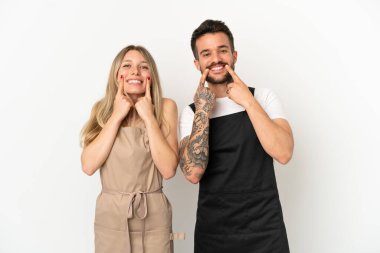 İzole edilmiş beyaz arka planda, mutlu ve hoş bir ifadeyle gülümseyen bir restoran garsonu.