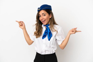 İzole edilmiş beyaz arka planda uçak hostesi parmak uçlarını gösteriyor ve mutlu.