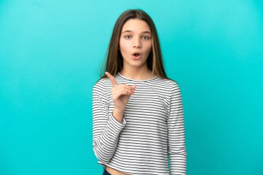 İzole edilmiş mavi arka plan üzerinde küçük bir kız parmağını kaldırarak çözümü anlamaya çalışıyor.