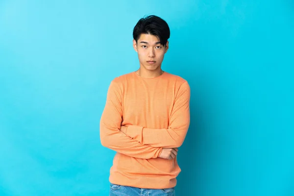 Genç Çinli Bir Adam Mavi Arka Planda Üzgün Bir Ifadeyle — Stok fotoğraf