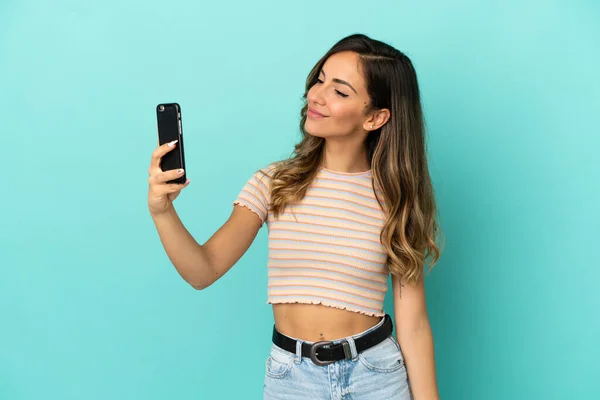 Mujer Joven Sobre Fondo Azul Aislado Haciendo Una Selfie — Foto de Stock
