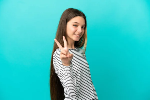 Menina Sobre Isolado Fundo Azul Sorrindo Mostrando Sinal Vitória — Fotografia de Stock