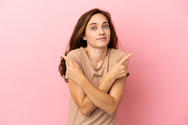 Jonge Kaukasische Vrouw Geïsoleerd Roze Achtergrond Wijzend Naar Lateralen Met — Stockfoto