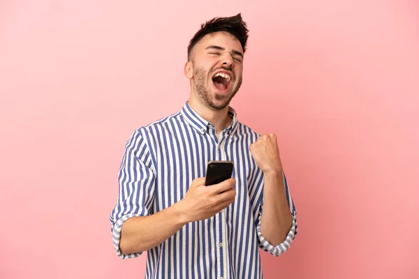 Mladý Kavkazský Muž Izolované Růžovém Pozadí Telefonem Vítězné Pozici — Stock fotografie