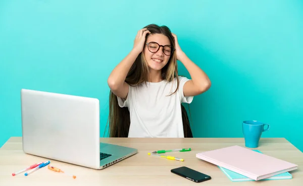 Menina Uma Mesa Com Laptop Sobre Fundo Azul Isolado Rindo — Fotografia de Stock