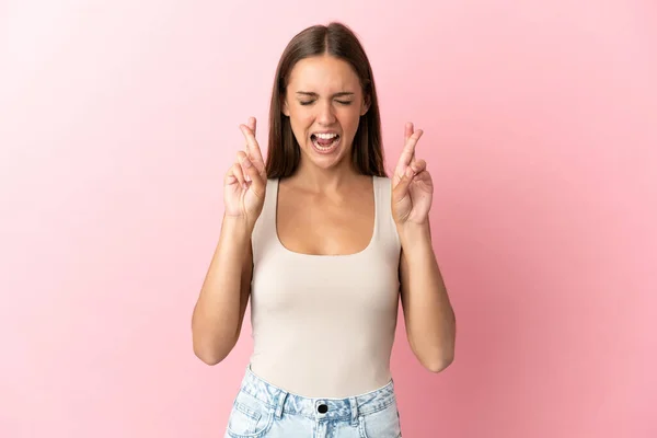 Mujer Joven Sobre Fondo Rosa Aislado Con Los Dedos Cruzando — Foto de Stock