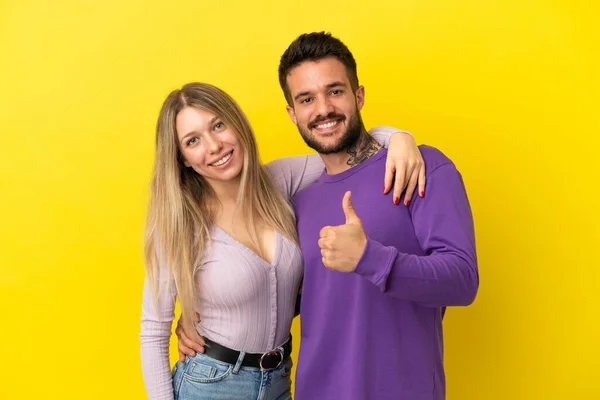 Junges Paar Auf Gelbem Hintergrund Mit Einer Daumen Hoch Geste — Stockfoto