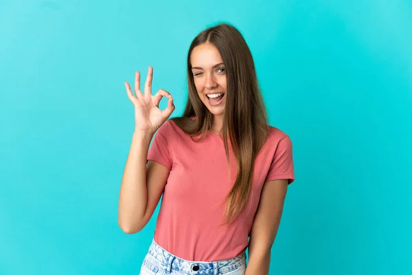 Zole Edilmiş Mavi Arka Plan Üzerinde Genç Bir Kadın Parmaklarıyla — Stok fotoğraf