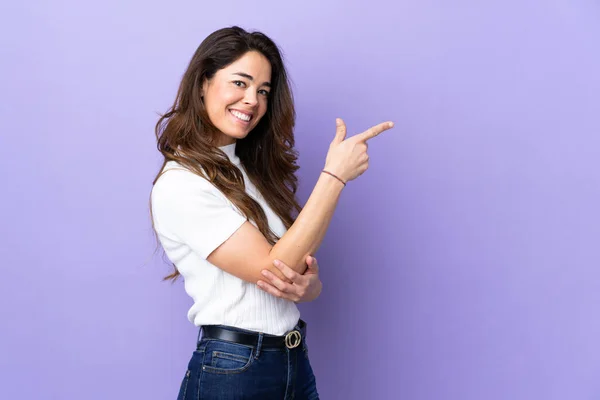 Woman Isolated Purple Background Pointing Finger Side — Stockfoto
