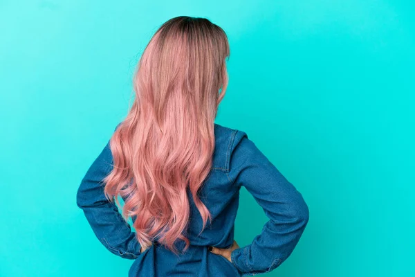 Молода Змішана Жінка Рожевим Волоссям Ізольована Синьому Фоні Положенні Спини — стокове фото