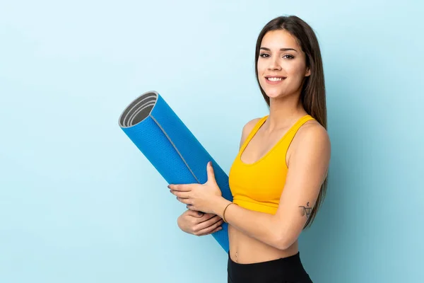 Joven Mujer Deportiva Con Alfombra Aislada Sobre Fondo Azul Sonriendo — Foto de Stock