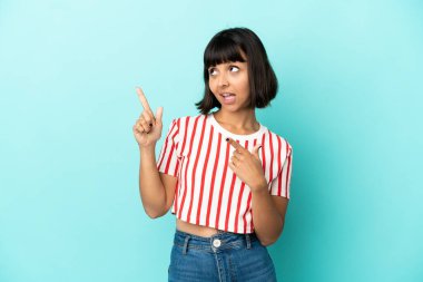 Mavi arka planda izole edilmiş genç melez kadın işaret parmağıyla işaret etmek harika bir fikir.