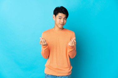 Genç Çinli adam mavi arka planda izole edilmiş para hareketi yapıyor ama mahvolmuş.